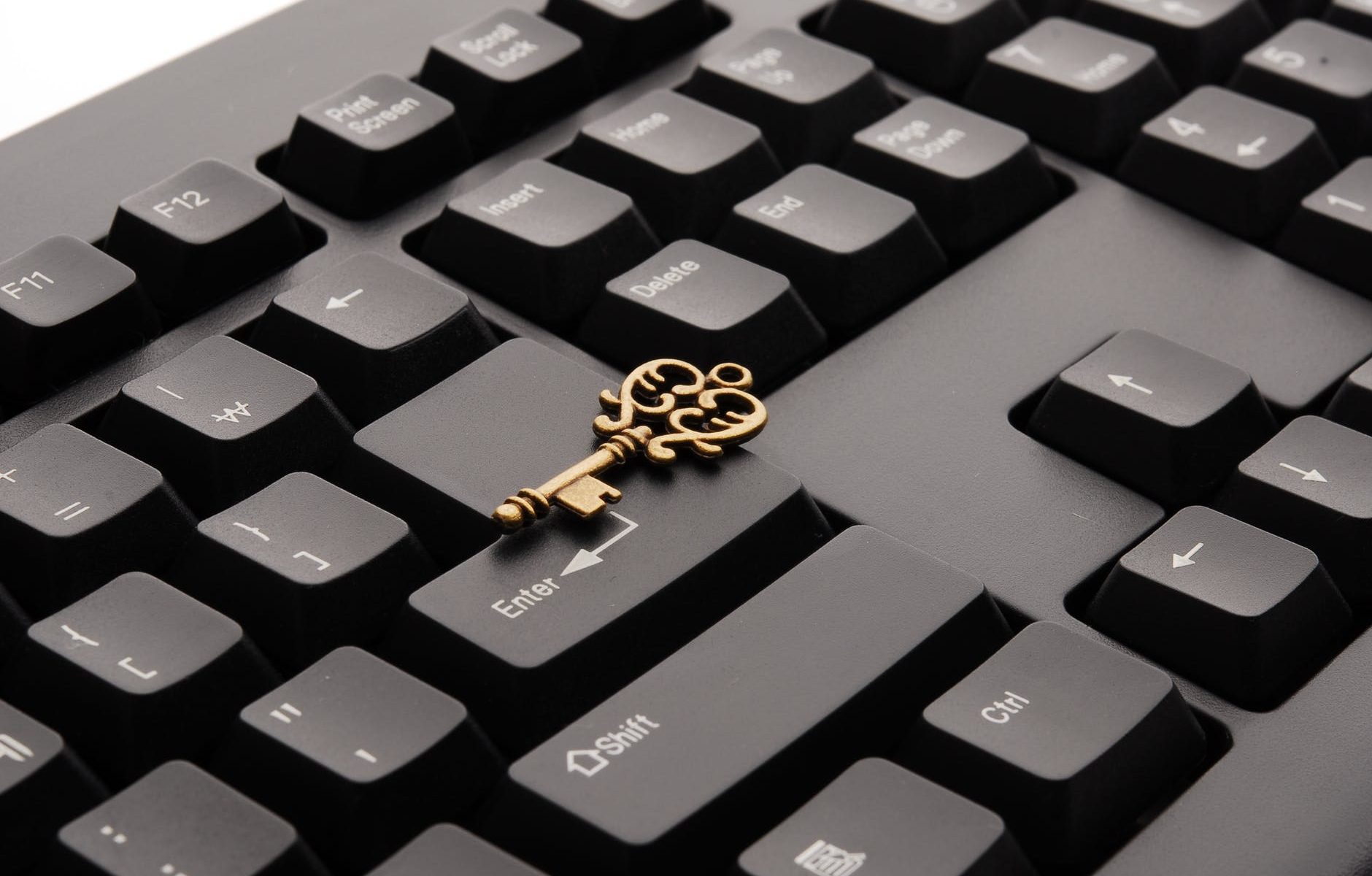 brass ornate vintage key on black computer keyboard