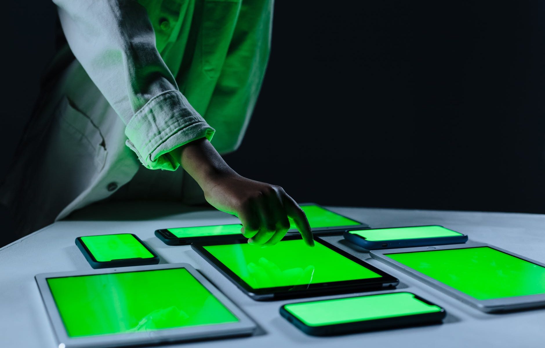 human hand touching ipad with green screen