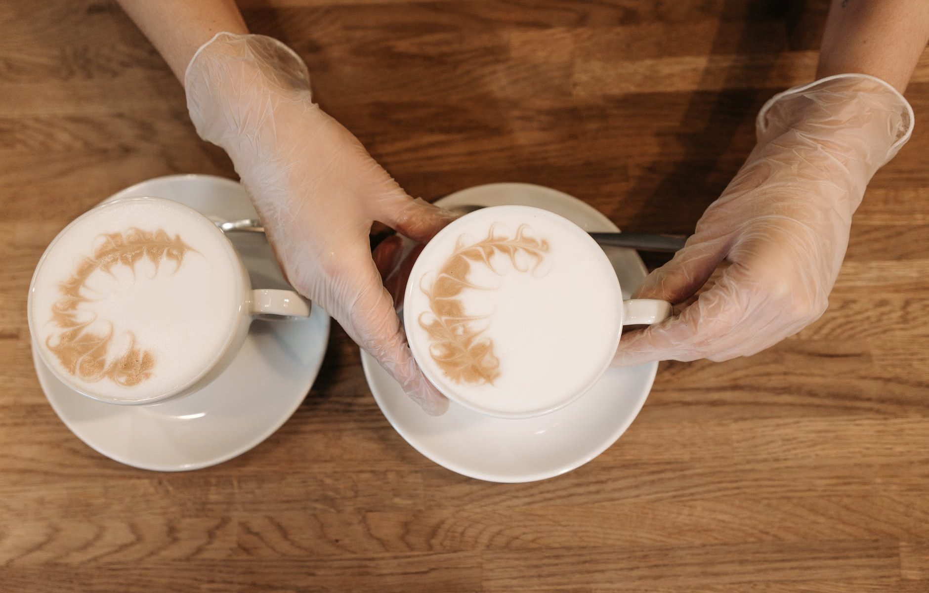 person holding white ceramic teacup with saucer