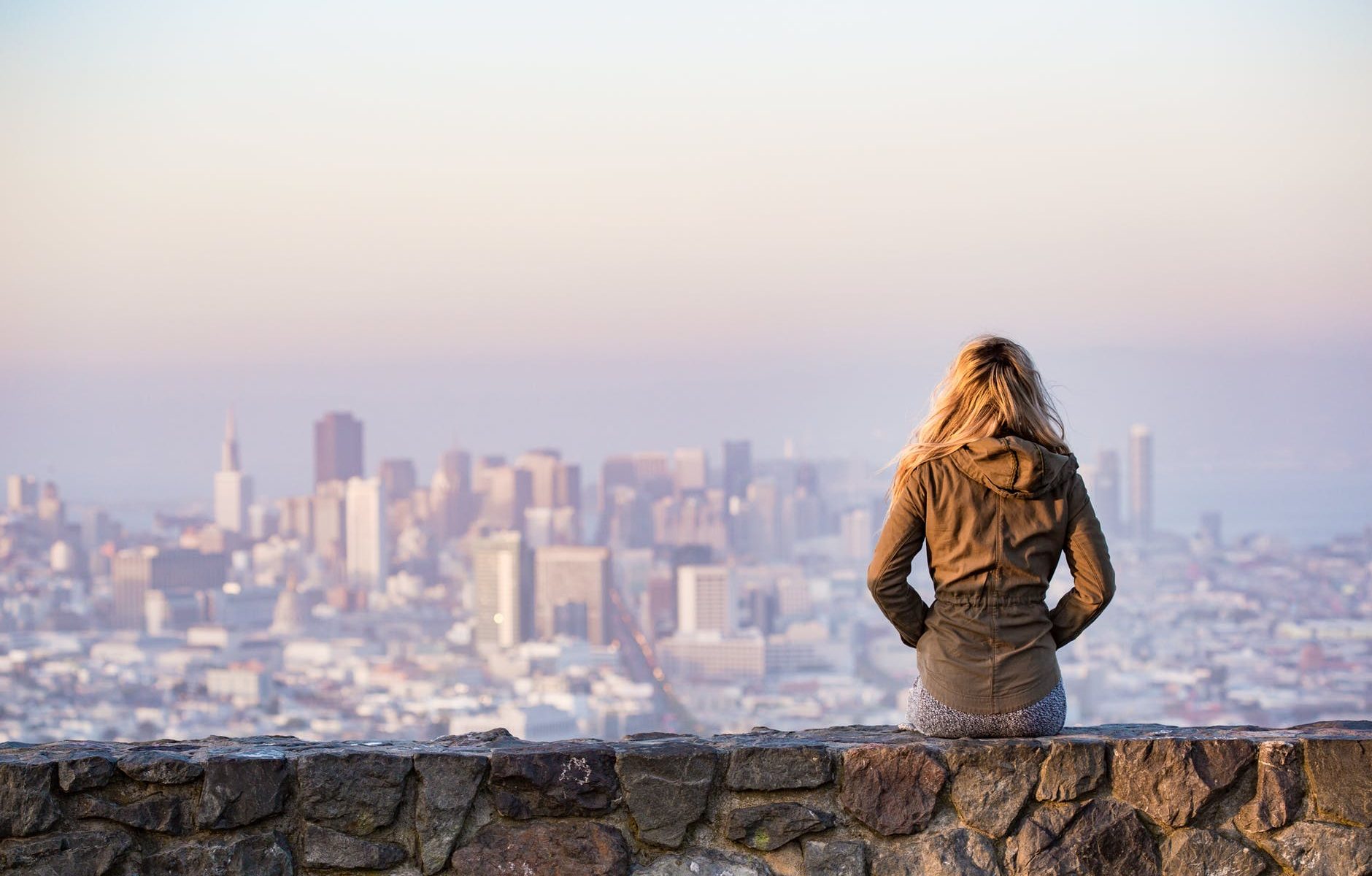 woman on rock platform viewing city