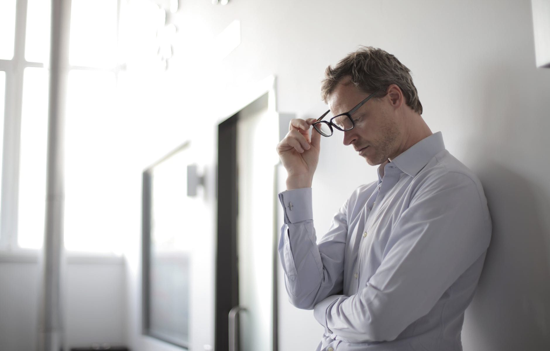 photo of man holding black eyeglasses