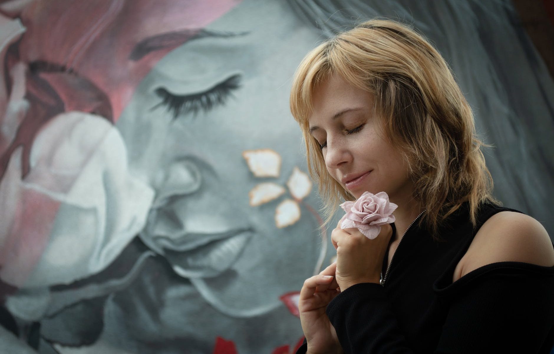 a woman imitating a painting of a woman holding a flower