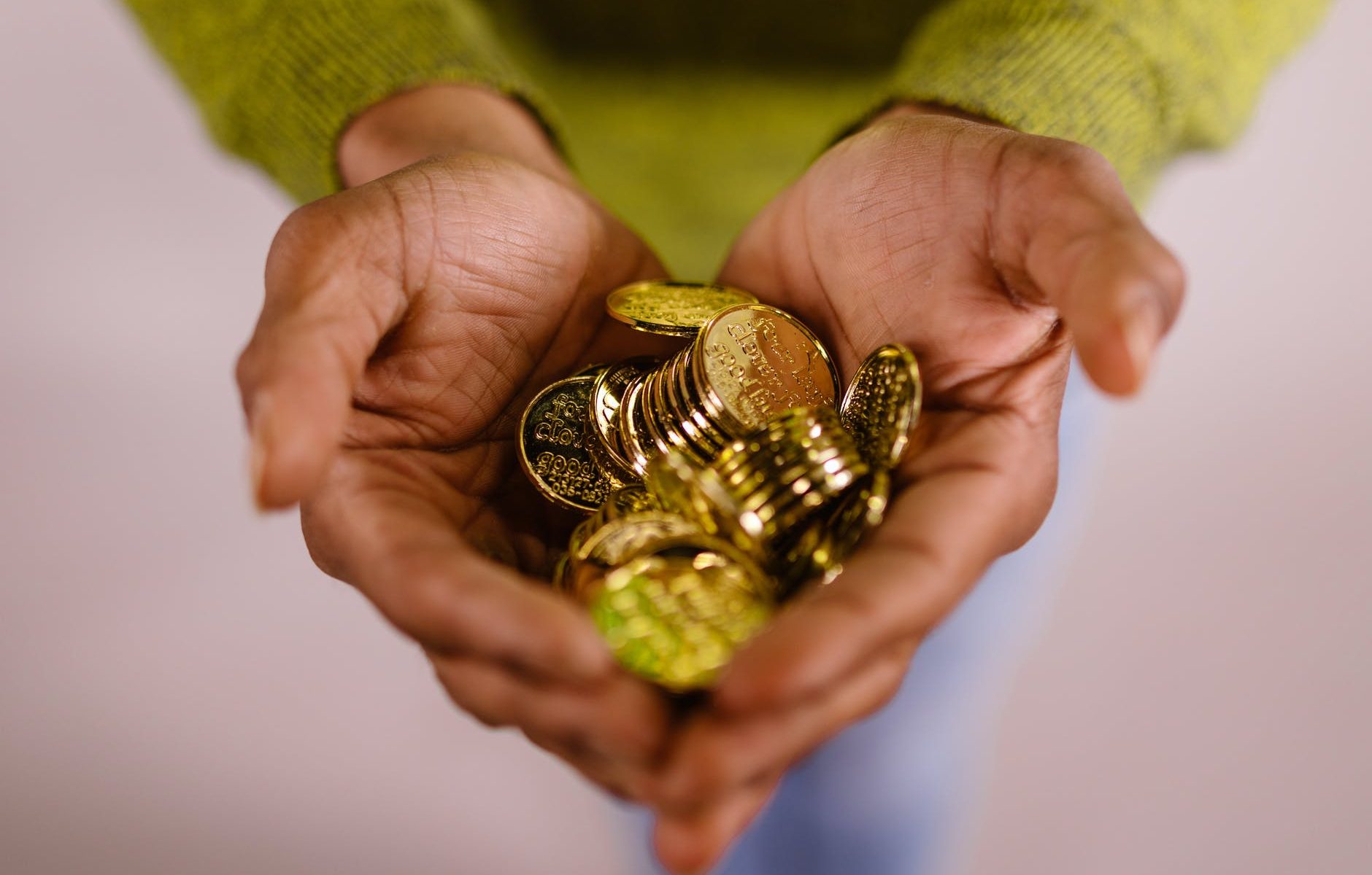 gold coins in person s hands