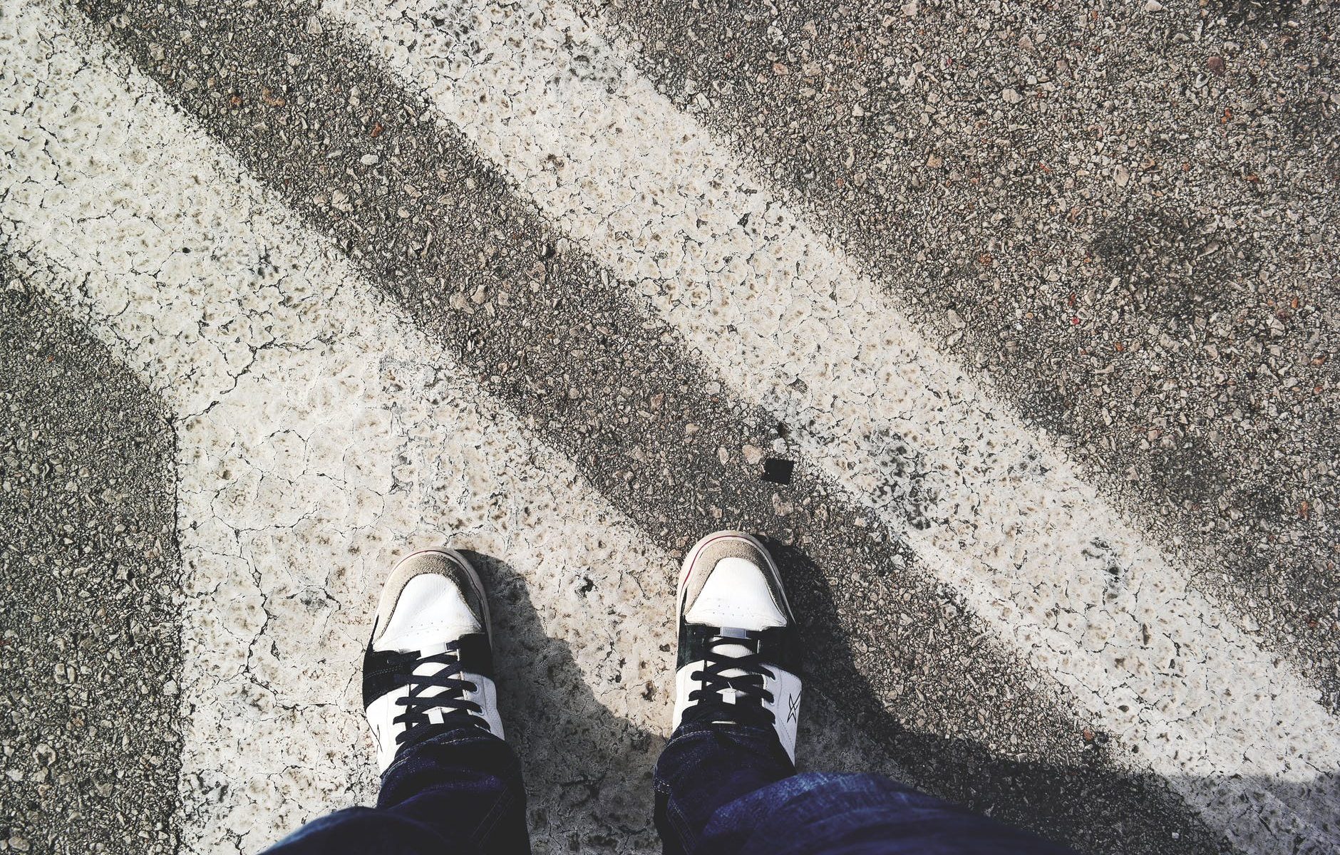 man in white and black sneakers standing outdoor during daytime