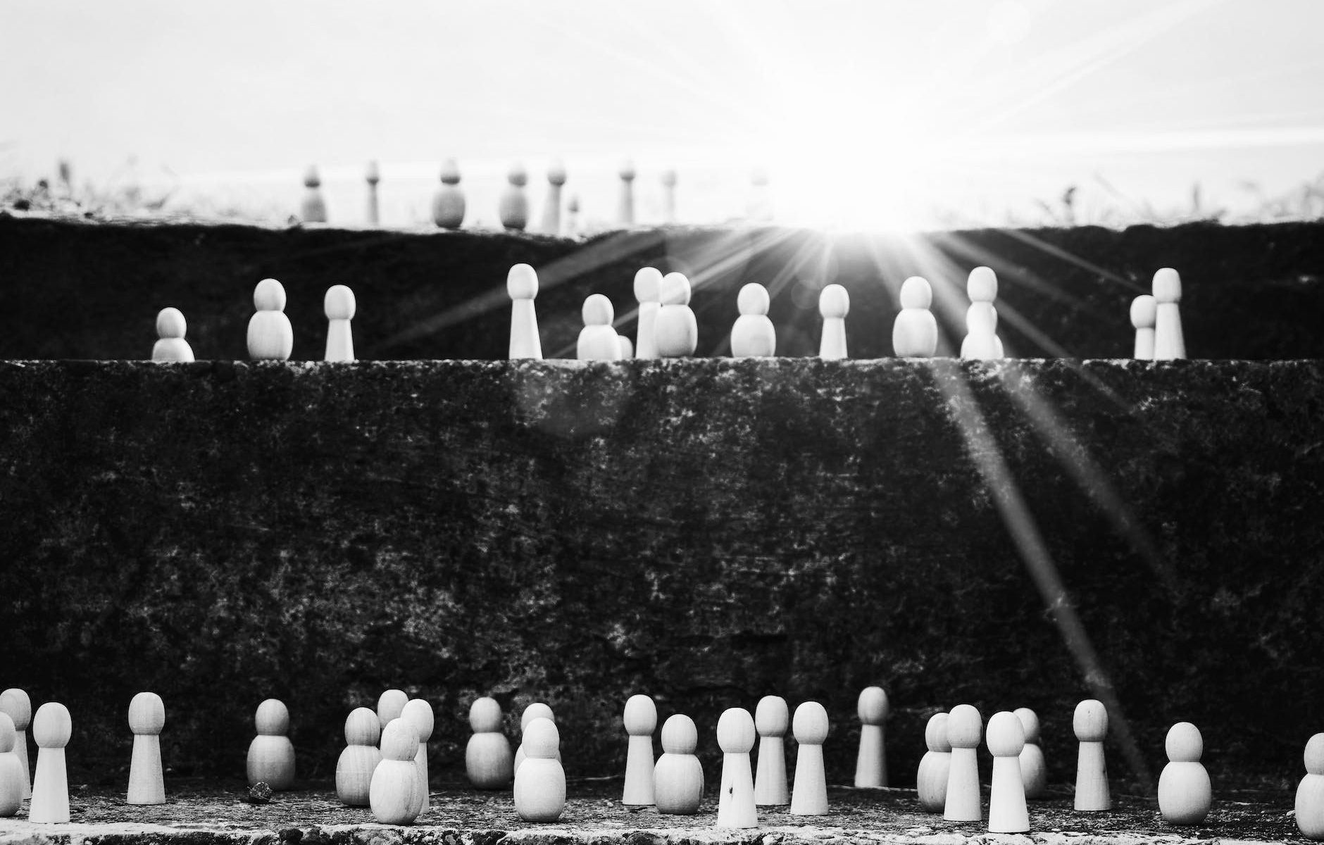 set of figurines on steps representing social ladder